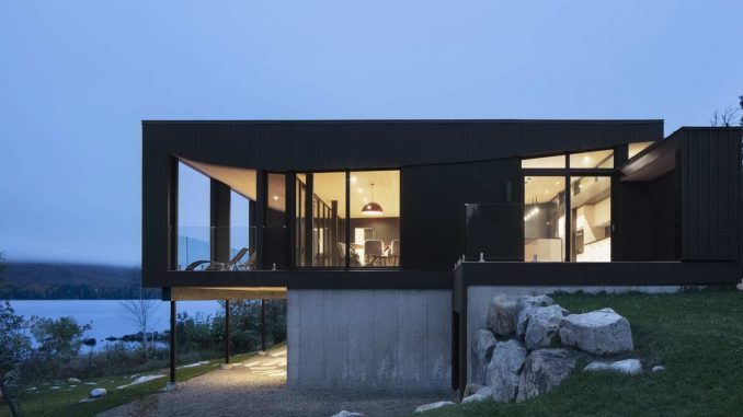 Чёрный дом с необычной крышей у озера в Канаде