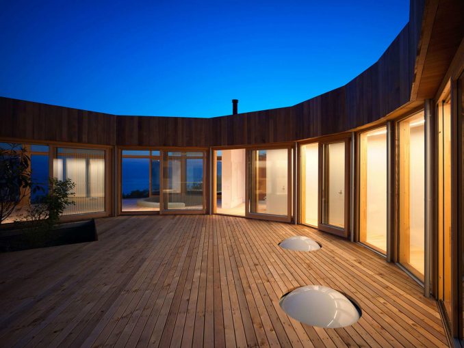 Круглый дом с двором и видом на гору и море в Японии 