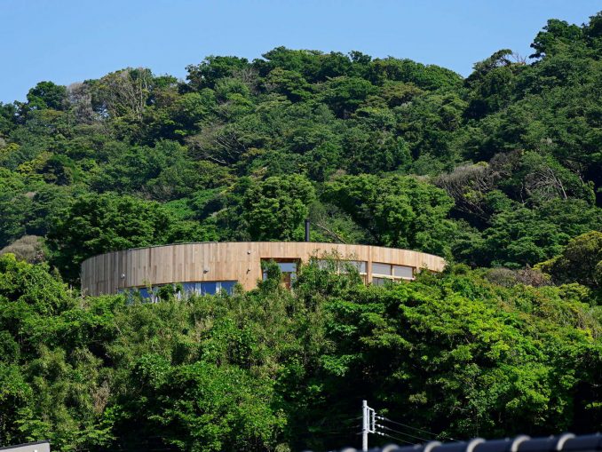Круглый дом с двором и видом на гору и море в Японии