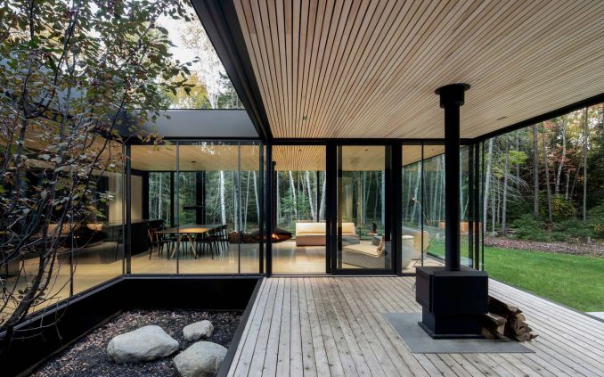 Чёрный минималистский дом с двориком на лесной поляне в Канаде 