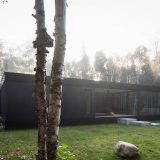 Чёрный минималистский дом с двориком на лесной поляне в Канаде