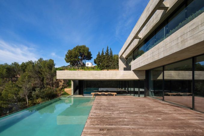 Бетонный дом с бассейном на склоне в Испании 